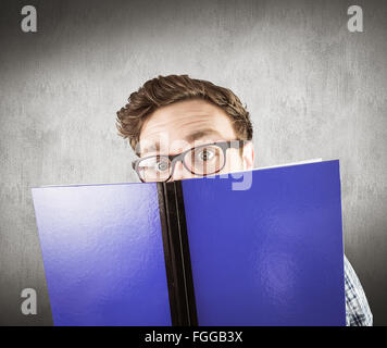 Zusammengesetztes Bild geeky Schüler ein Buch zu lesen Stockfoto