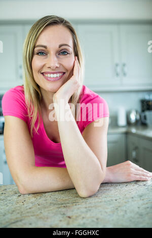 Hübsche blonde Frau an der Theke gelehnt Stockfoto