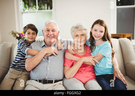 Großeltern und Enkel sitzen zusammen auf sofa