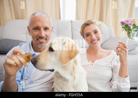 Brautpaar mit ihrem Haustier Hund Champagner trinken Stockfoto