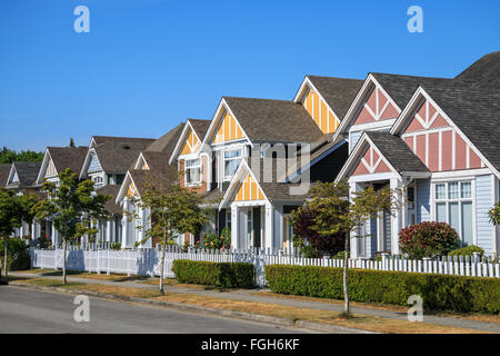Eine Reihe von neuen Häusern in Richmond, British Columbia, Kanada. Vorgärten der Häuser und der Straße mit Bäumen und Sträuchern. Stockfoto