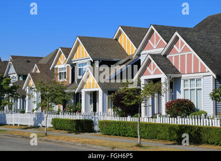 Eine Reihe von neuen Häusern in Richmond, British Columbia, Kanada. Vorgärten der Häuser und der Straße mit Bäumen und Sträuchern. Stockfoto