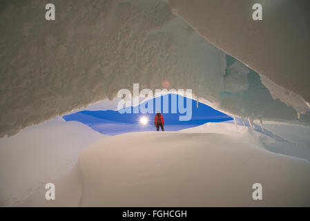 Eine Person steht vor einem Höhleneingang Eis auf Ross Island, Antarktis. Stockfoto