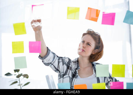 nachdenklich Hipster Frau brainstorming über Noten Stockfoto