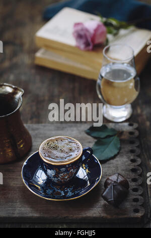 Eine Tasse türkischen Kaffee mit Schaum an der Spitze wird auf einem Vintage Holz Teller fotografiert. Stockfoto