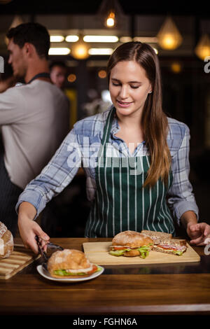 Hübsche Barista aufsetzen Sandwich in einer Schale Stockfoto