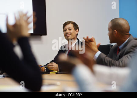 Gruppe von Geschäftsleuten treffen in corporate Konferenzraum, applaudieren bei einem Kollegen während seines Vortrags. Der Mann ist show Stockfoto