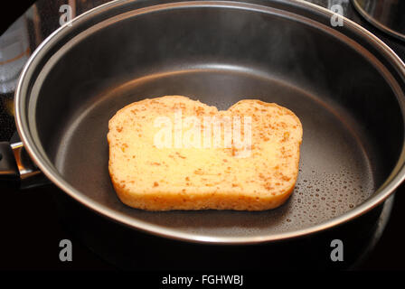 Eine Scheibe rohen Französisch Toast Kochen in einer Pfanne anbraten Stockfoto