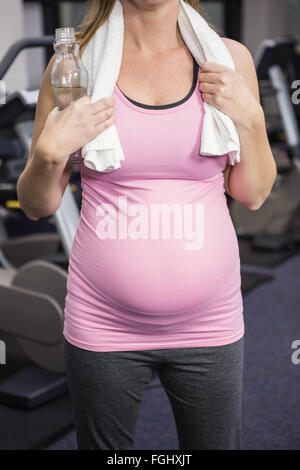 Schwangere Frau stand neben Heimtrainer Stockfoto