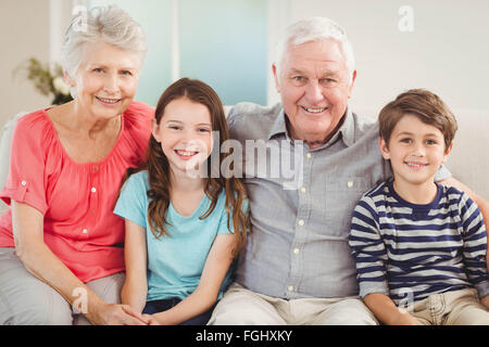 Großeltern und Enkel sitzen zusammen auf sofa Stockfoto