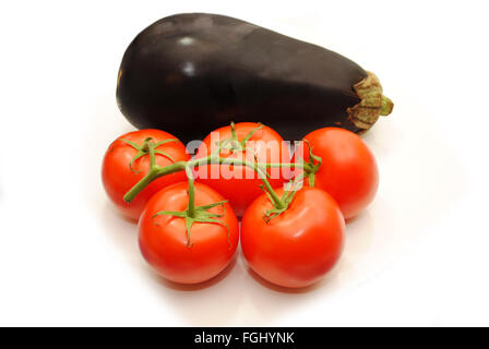 5 Tomaten auf einem Weinstock mit einer Aubergine Stockfoto