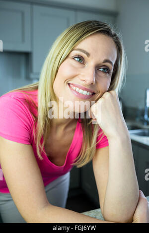 Hübsche blonde Frau an der Theke gelehnt Stockfoto