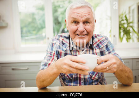 Lächelnder senior Mann am Tisch sitzen Stockfoto