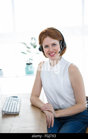 lächelnde Hipster-Business-Frau trägt einen Kopfhörer Stockfoto