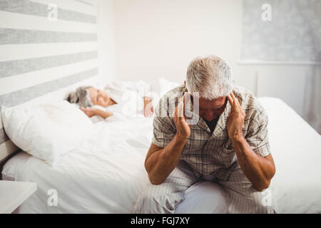 Frustriert senior Mann sitzt auf Bett Stockfoto