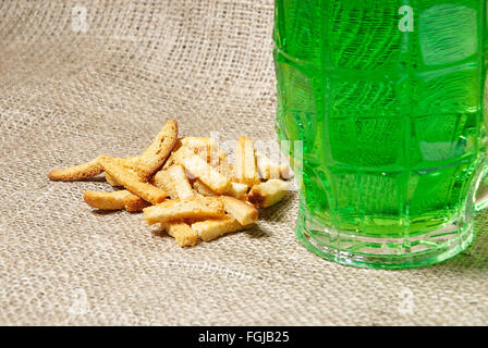 Glas Irish Jungbier und Cracker auf Sackleinen Hintergrund. Traditionelle Symbole der St. Patricks day Stockfoto