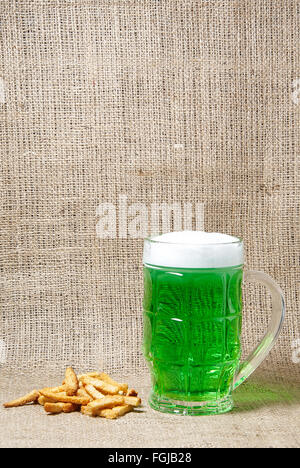 Glas Irish Jungbier und Cracker auf Sackleinen Hintergrund. Traditionelle Symbole der St. Patricks Day. Platz für text Stockfoto