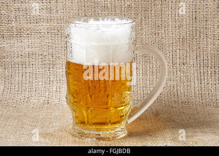Glas Bier auf Sackleinen Hintergrund. Schließen Sie herauf Bild Stockfoto