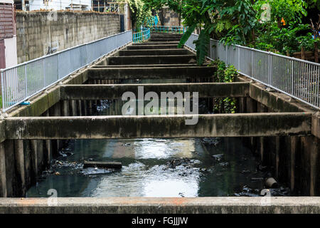 Verschmutzten Kanal zwischen Häusern in der Innenstadt von Bangkok, Thailand nahe dem Fluss Chao Phraya. Stockfoto