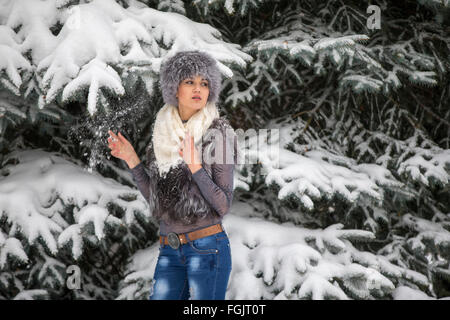 Die Frau in einem eleganten Schal gegen das Holz und Schnee im Winter Weihnachten Stockfoto