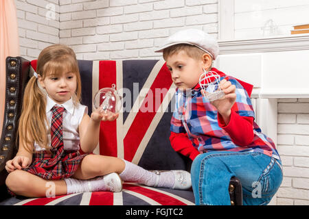 Mädchen und Jungen auf Stuhl sitzend mit britischer Flagge Stockfoto