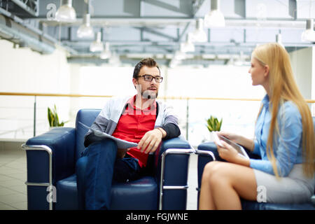 Zwei Mitarbeiter diskutieren Pläne im Büro Stockfoto