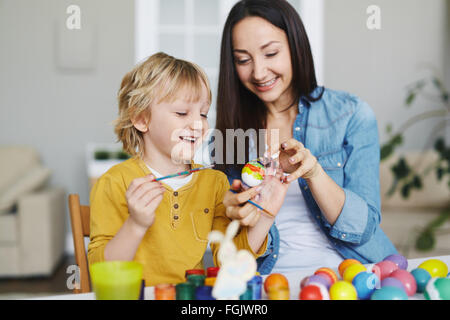 Glückliche Frau und netten jungen bemalen von Ostereiern Stockfoto