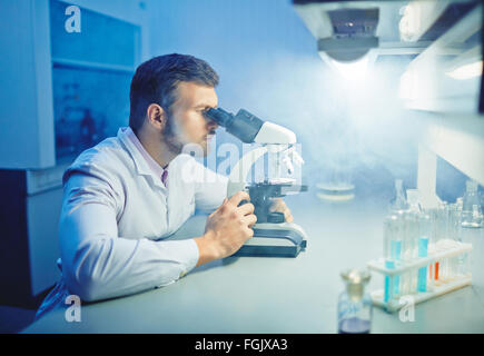 Moderne Wissenschaftler mit Mikroskop mikrobiologische Untersuchung Stockfoto