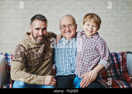 Glücklich reifer Mann, junger Mann und kleiner Junge auf sofa Stockfoto