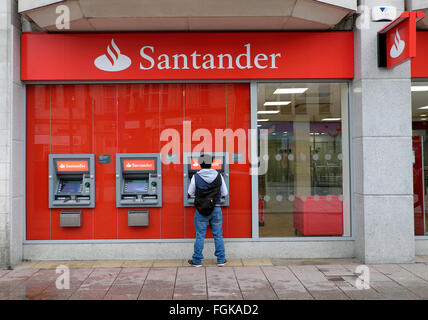 Mann immer aus Bargeld an Geldautomaten der Santander in Queen Street, Cardiff City Centre Wales UK KATHY DEWITT Stockfoto