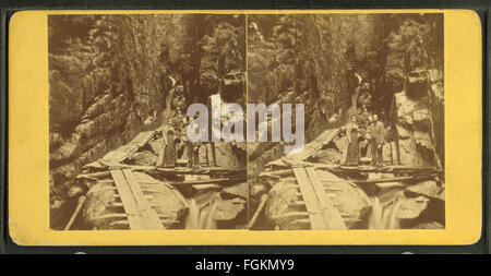 Dieses historische Foto von H. S. Fifield aus dem Jahr 1879 zeigt die Besucher der Flume, einem berühmten Wasserspiel oder Naturschauplatz. Das Bild fängt die Kleidung der Besucher und die umliegende Landschaft ein und spiegelt das Leben im späten 19. Jahrhundert wider. Stockfoto