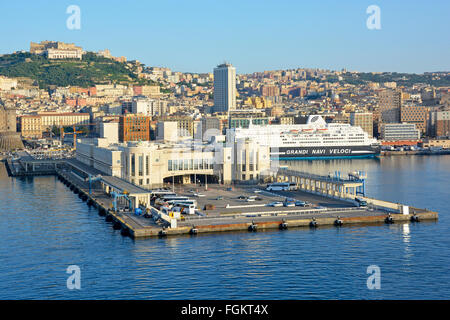 Naples Italien am frühen Morgen Sonnenschein über die Kreuzfahrt Schiff terminal und Schifffahrt im Hafen von Neapel mit hügeligen Stadtbild jenseits Stockfoto