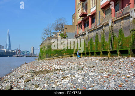 Wapping & Themse Vorland bei Ebbe zeigt alte Grundmauern am Flussufer Lagergebäude mit Tower Bridge & Shard über London England UK Stockfoto