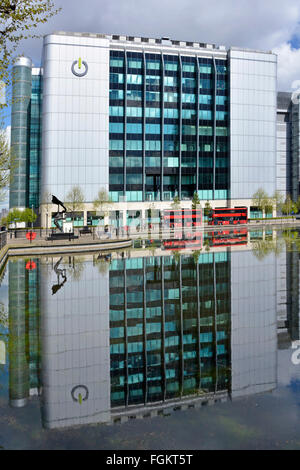 Global Switch Rechenzentrumsanbieter: Räumlichkeiten und Reflexionen in landschaftlich gestaltetem Wasser Merkzettel Buswerbung digital entfernt East End of London England Großbritannien Stockfoto