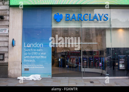 Einen starken Kontrast zwischen einem Obdachlosen auf der Straße und eine internationale Bank in London schlafen Stockfoto