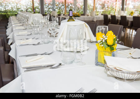 Tisch im Restaurant zubereiten für Parteien, haben die gelbe rose, grauer Stuhl und Weinflasche im Korb Stockfoto