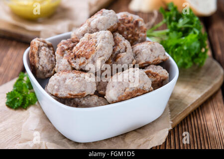 Kleine hausgemachte Frikadellen (Tiefenschärfe) auf einem alten Holztisch Stockfoto