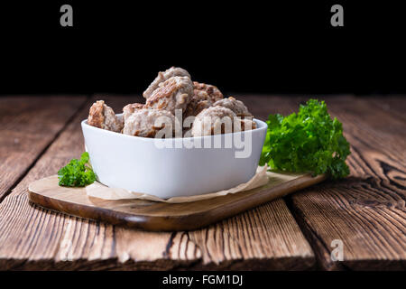 Kleine hausgemachte Frikadellen (Tiefenschärfe) auf einem alten Holztisch Stockfoto