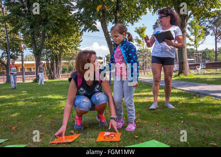 Józefów, Polen - 19. September 2015: Eltern mit Kindern spielen verschiedene Spiele auf dem Rasen im Park im Stadtzentrum Stockfoto