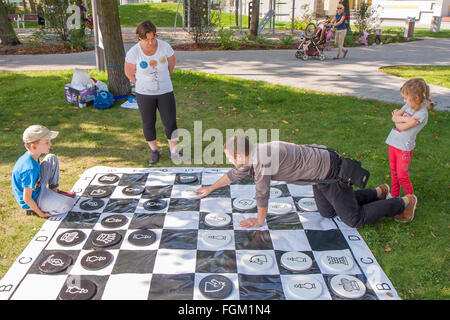 Józefów, Polen - 19. September 2015: Eltern mit Kindern spielen verschiedene Spiele auf dem Rasen im Park im Stadtzentrum Stockfoto