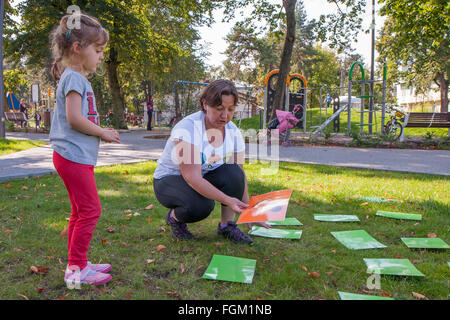 Józefów, Polen - 19. September 2015: Eltern mit Kindern spielen verschiedene Spiele auf dem Rasen im Park im Stadtzentrum Stockfoto