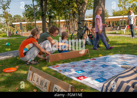 Józefów, Polen - 19. September 2015: Eltern mit Kindern spielen verschiedene Spiele auf dem Rasen im Park im Stadtzentrum Stockfoto