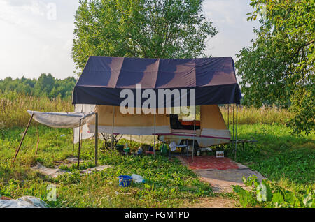 Dorfbild. Anhänger mit Zelt-Haus im Garten. Stockfoto