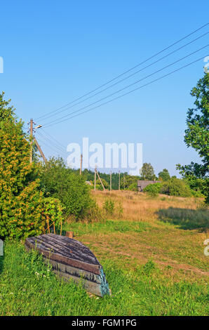 Dorfbild. Alten Holzboot in der Nähe von Garten. Stockfoto