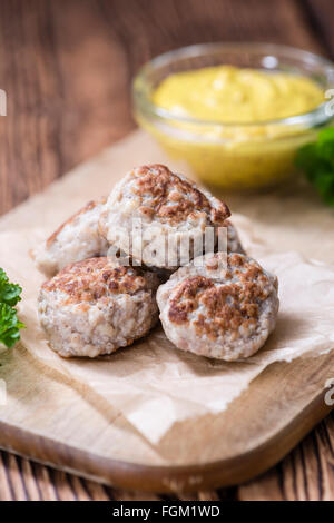 Kleine hausgemachte Frikadellen (Tiefenschärfe) auf einem alten Holztisch Stockfoto