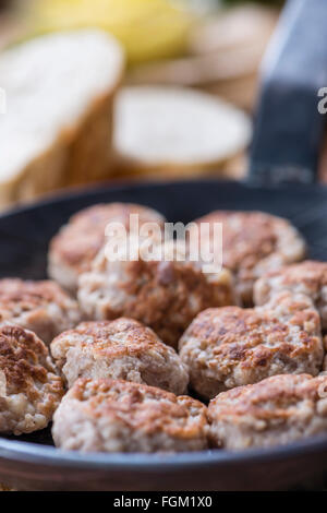 Kleine hausgemachte Frikadellen (Tiefenschärfe) auf einem alten Holztisch Stockfoto