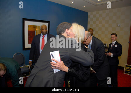 Overland Park, Kansas, USA, 19. Februar 2016 Gouverneur Sam Brownback umarmt Frankie Roberts die Ehefrau von US-Senator Pat Roberts seine Rezeption während des republikanischen Konvents Credit: mark Reinstein/Alamy Live-Nachrichten Stockfoto