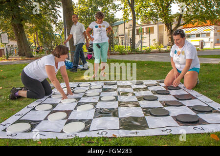 Józefów, Polen - 19. September 2015: Eltern mit Kindern spielen verschiedene Spiele auf dem Rasen im Park im Stadtzentrum Stockfoto