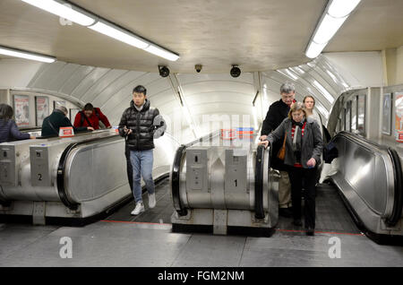 Passagiere kommen an der Spitze einer Fahrtreppe in einer Londoner u-Bahn-Station. Stockfoto