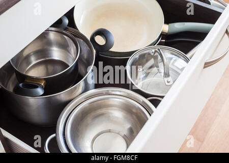 Geöffnete Schublade Schrank mit Stahl Töpfe und Pfannen und Schüssel. Küche Geschirr Hintergrund Stockfoto